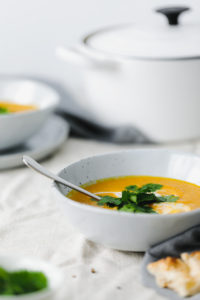 spiced carrot & ginger soup with coconut milk - pot in background | curatedlifestudio.com